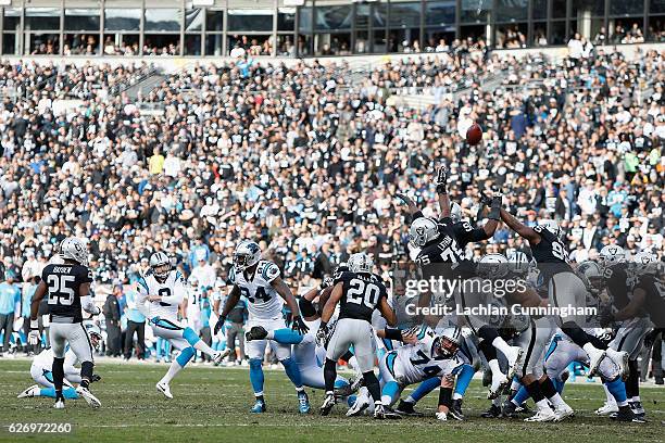 Denico Autry of the Oakland Raiders blocks an attempted point after a touchdown by Graham Gano of the Carolina Panthers on November 27, 2016 in...