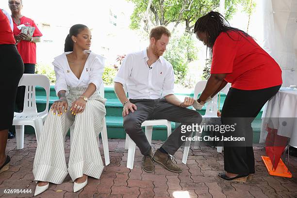 Singer Rihanna watches as Prince Harry gets his blood sample taken for an live HIV test, in order to promote more widespread testing for the public...