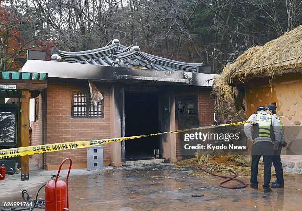 South Korean officials stand by the partly burned birthplace of the late President Park Chung Hee, the father of President Park Geun Hye, in Gumi,...