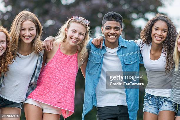 friends standing together outside - toothy smile stock pictures, royalty-free photos & images