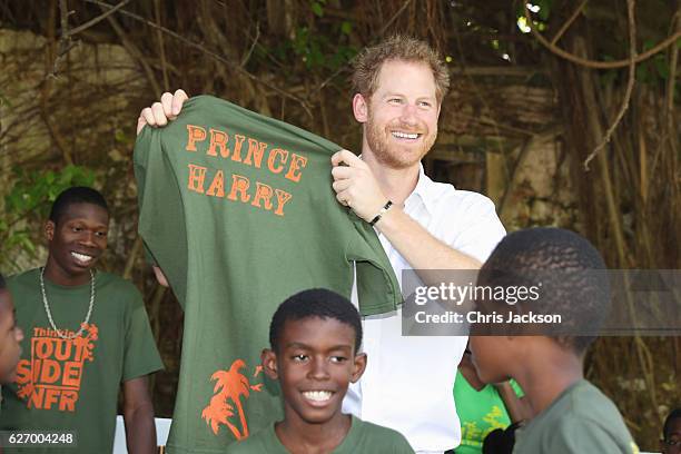 Prince Harry poses with a t-shirt at the 'Nature Fun Ranch' on the eleventh day of an official visit on December 1, 2016 in St Andrew, Barbados. The...