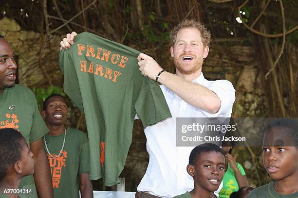 Prince Harry poses with a t-shirt at the 'Nature Fun Ranch' on the eleventh day of an official visit on December 1, 2016 in St Andrew, Barbados. The...