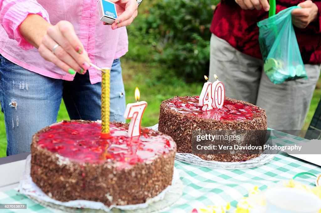 Woman lighting candles on birthday cakes