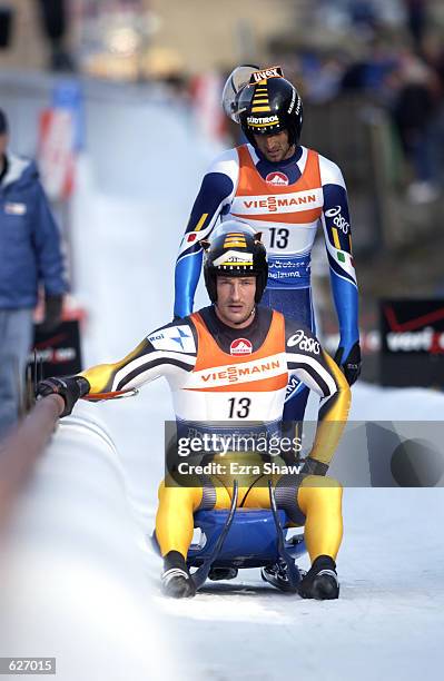 Gerhard Plankensteiner and Oswald Haselrieder of Italy arrive at the finish during the men's doubles of the Luge World Cup at Mt. Van Hoevenberg in...