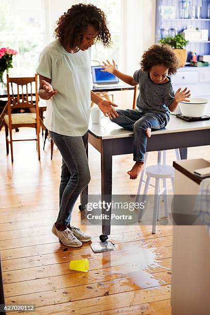 shocked mother and son looking at fallen milk - messy table stock pictures, royalty-free photos & images