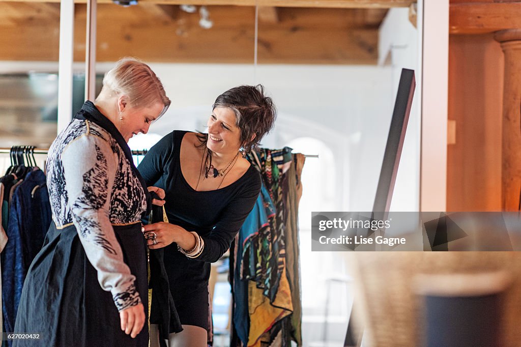 Fashion designer  taking customer measurement in clothing boutique