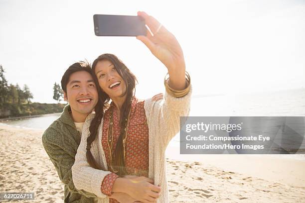 couple taking self portrait on beach - canadian pacific women stock pictures, royalty-free photos & images