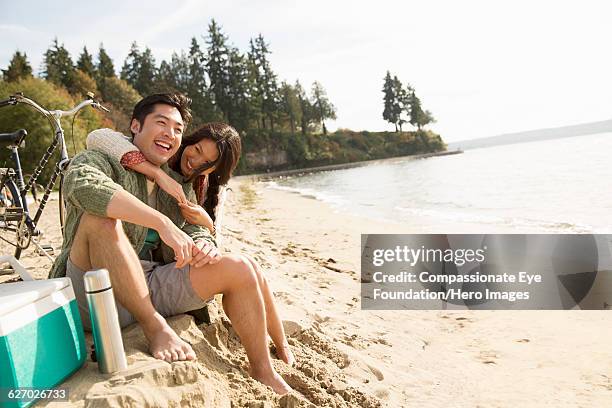 smiling couple hugging on beach - vancouver stock pictures, royalty-free photos & images