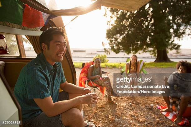 friends relaxing by camper van - camper van imagens e fotografias de stock