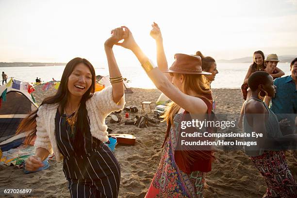 friends enjoying dancing on beach - social action party stock pictures, royalty-free photos & images