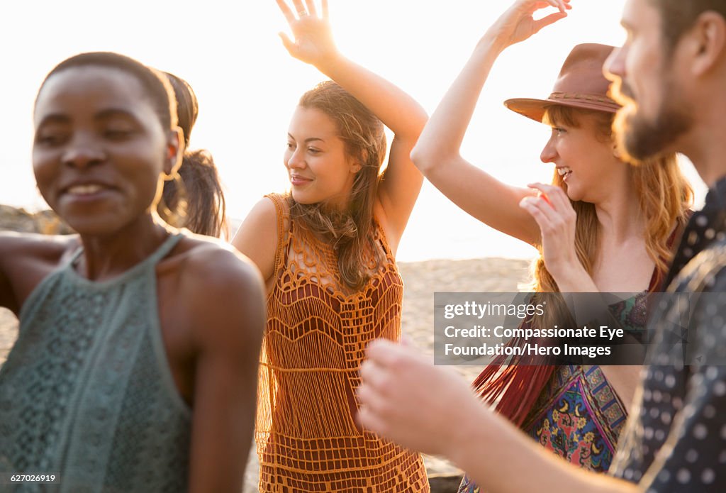 Friends enjoying dancing on beach