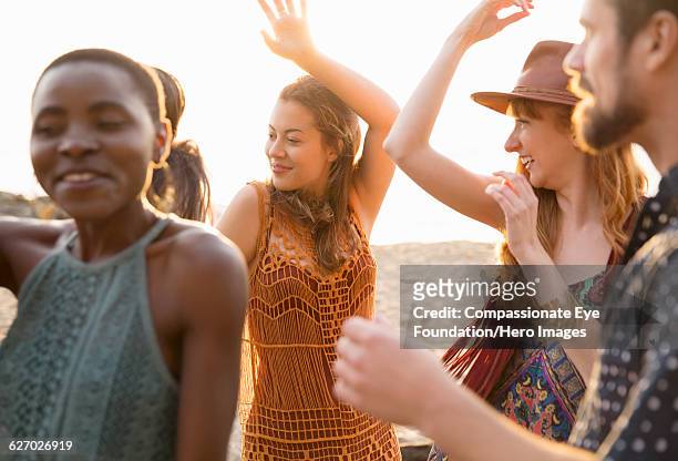 friends enjoying dancing on beach - social action party stock pictures, royalty-free photos & images