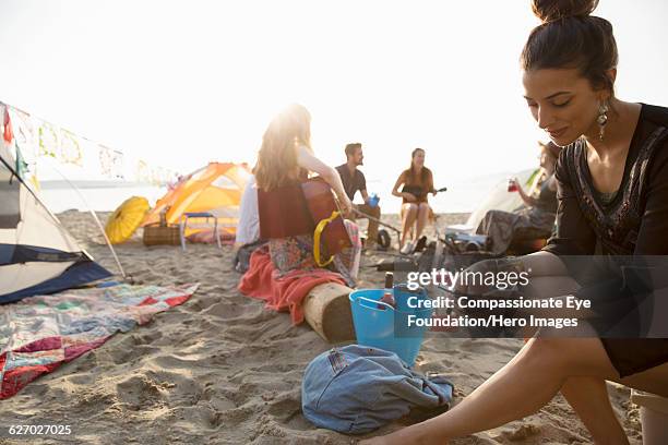 woman texting on cell phone on beach - riva del lago foto e immagini stock