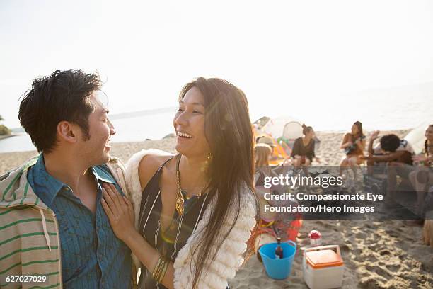 couple hanging out on beach with friends - chinese hero fotografías e imágenes de stock