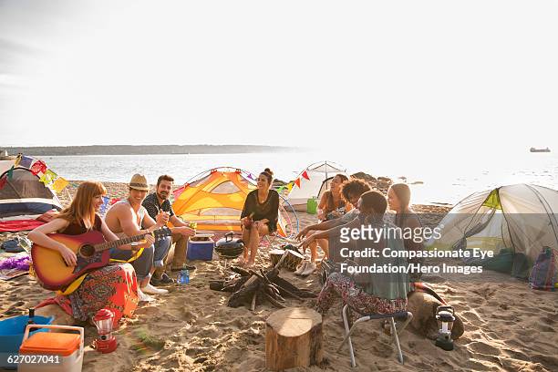 friends hanging out and playing guitar on beach - british columbia beach stock pictures, royalty-free photos & images