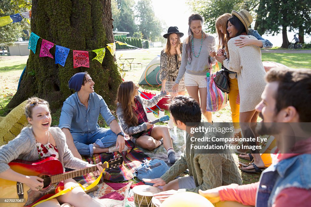 Friends hanging out relaxing on blanket in park