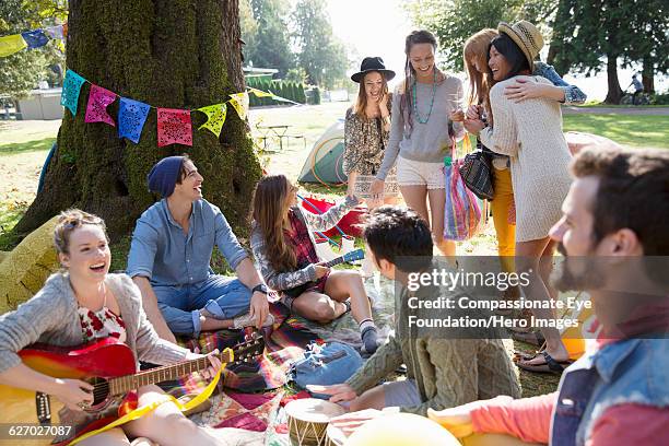 friends hanging out relaxing on blanket in park - park festival stock pictures, royalty-free photos & images