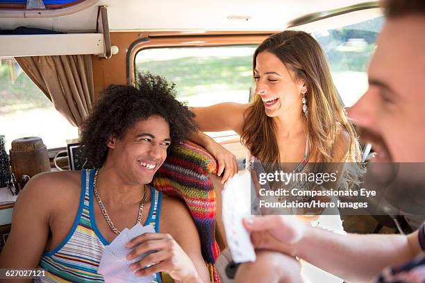 friends enjoying playing cards in camper van - 3 guy friends road trip stock-fotos und bilder