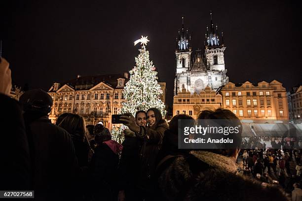 People pose for a selfie in front of the Christmas tree at the Christmas market at Old Town Square in Prague, Czech Republic on December 1, 2016....