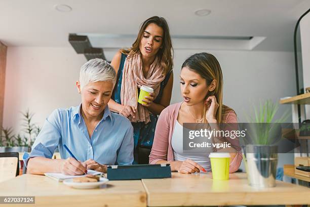 frauen, die in ihrem startup-büro arbeiten. - kaffeeklatsch stock-fotos und bilder