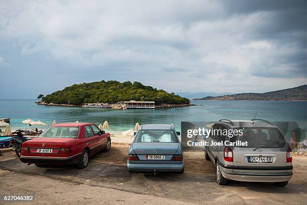 cars parked at beach in ksamil, albania - sarande albania stock pictures, royalty-free photos & images