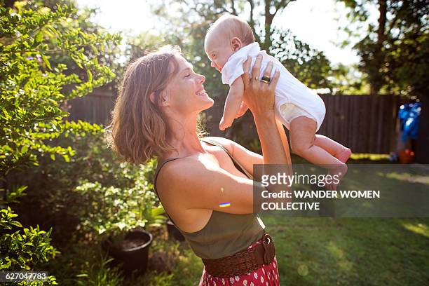 real mother and baby in garden on summer day - in real life stock-fotos und bilder