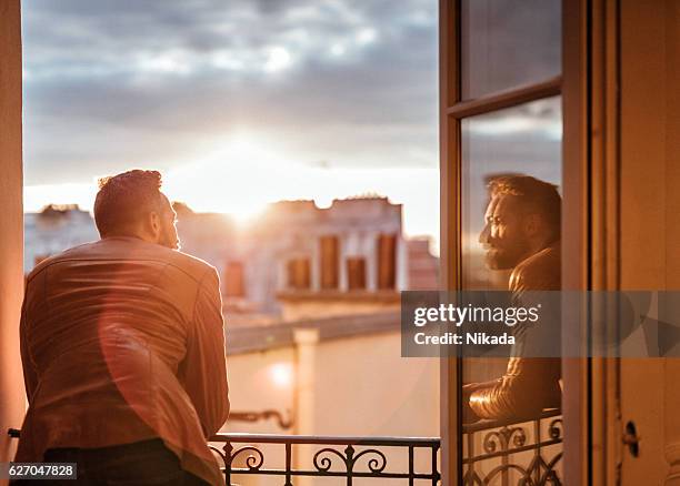 bearded man looking out over the city at sunrise - twilight house stock pictures, royalty-free photos & images