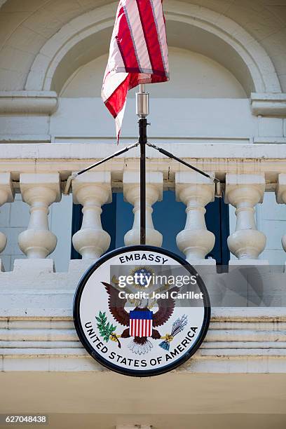 american embassy seal and u.s. flag in moldova - embassy stock pictures, royalty-free photos & images