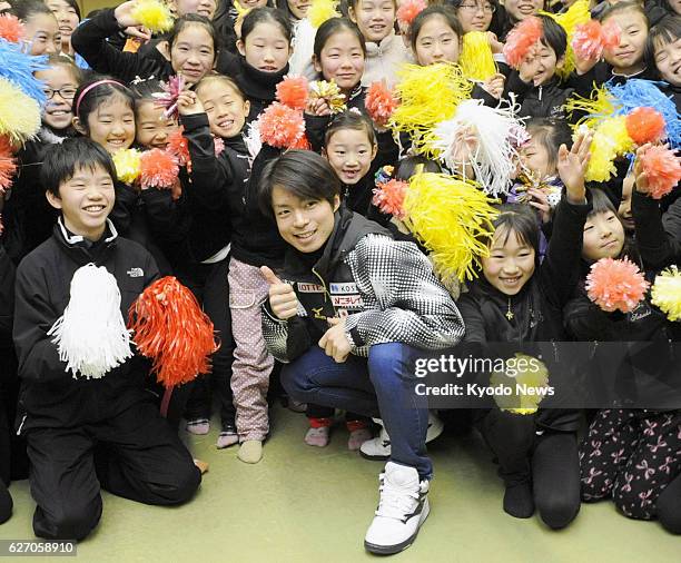 Japan - Japanese male figure skater Tatsuki Machida, who will compete at the Sochi Olympics in Russia in February, poses with children for a snapshot...