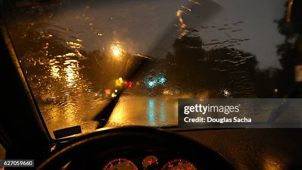 moving windshield wiper view of a moving vehicle - car rain stock pictures, royalty-free photos & images