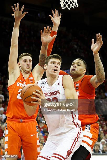 Ethan Happ of the Wisconsin Badgers handles the ball while being guarded by Tyler Lydon and DaJuan Coleman of the Syracuse Orange in the first half...