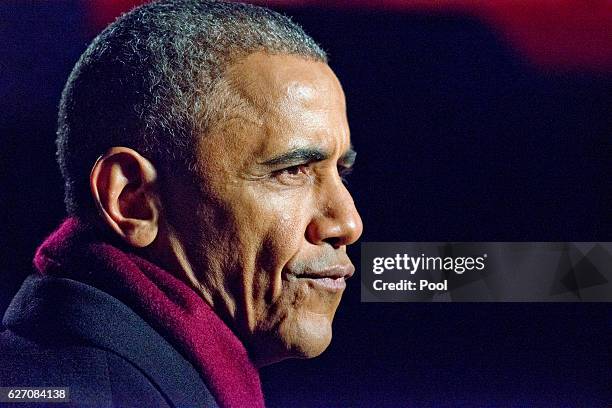 President Barack Obama grimaces during one of the many production delays as he and the first family attend the National Christmas Tree Lighting on...