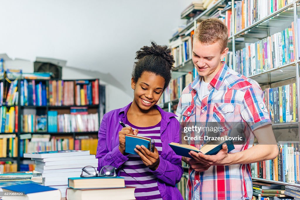 Glücklich high-school-Schüler in der Bibliothek mit Büchern