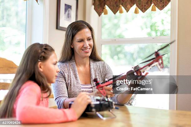 mother and daughter looking at drones for a science project - radio controlled handset stock pictures, royalty-free photos & images