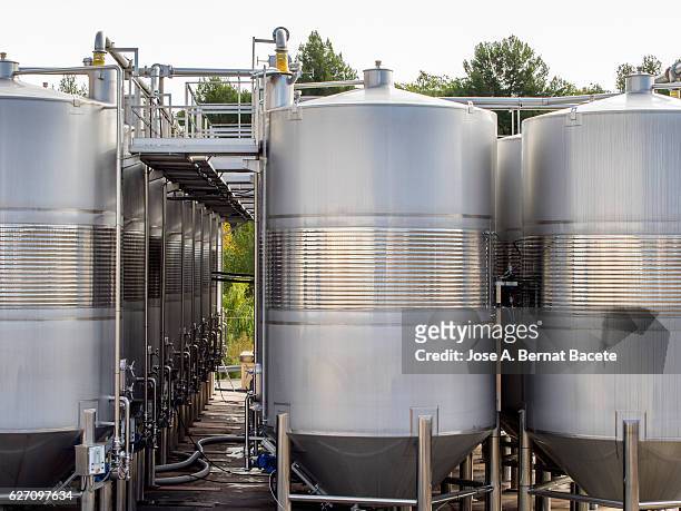 pipelines of tanks of wine outdoors of an industrial warehouse. - fermentation tank stock pictures, royalty-free photos & images