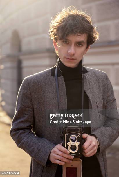 young man photographing with retro camera, outdoors - 都會型男 個照片及圖片檔