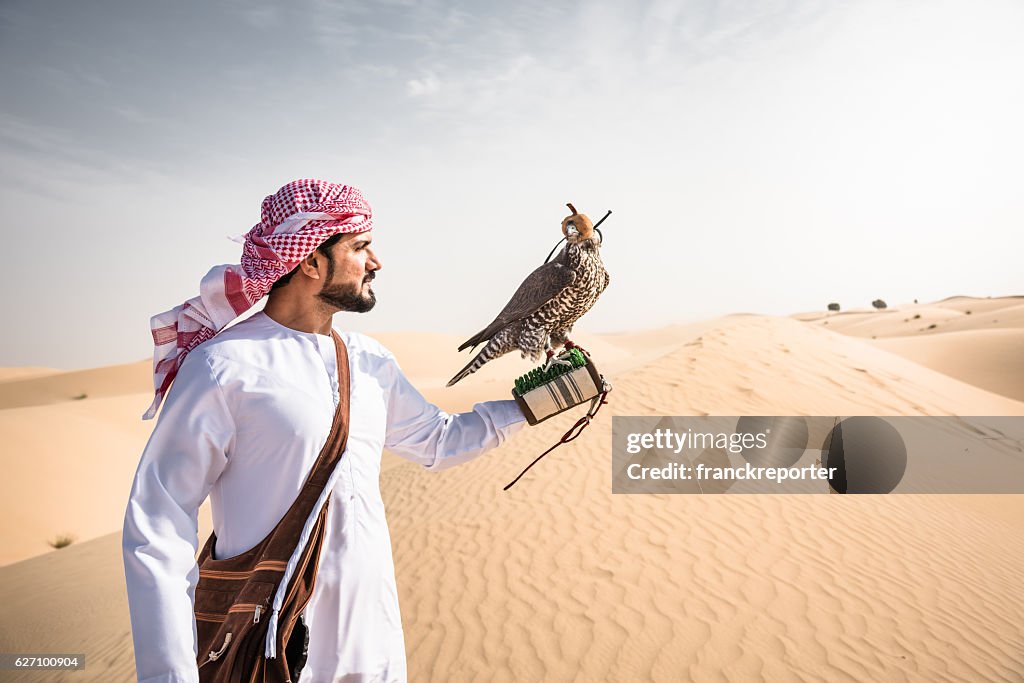 Arabic sheik on the desert holding a falcon