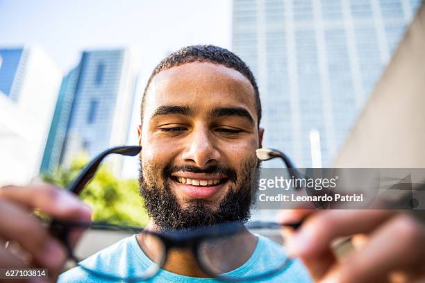 man holding and putting his own glasses on - get dressed male stock pictures, royalty-free photos & images
