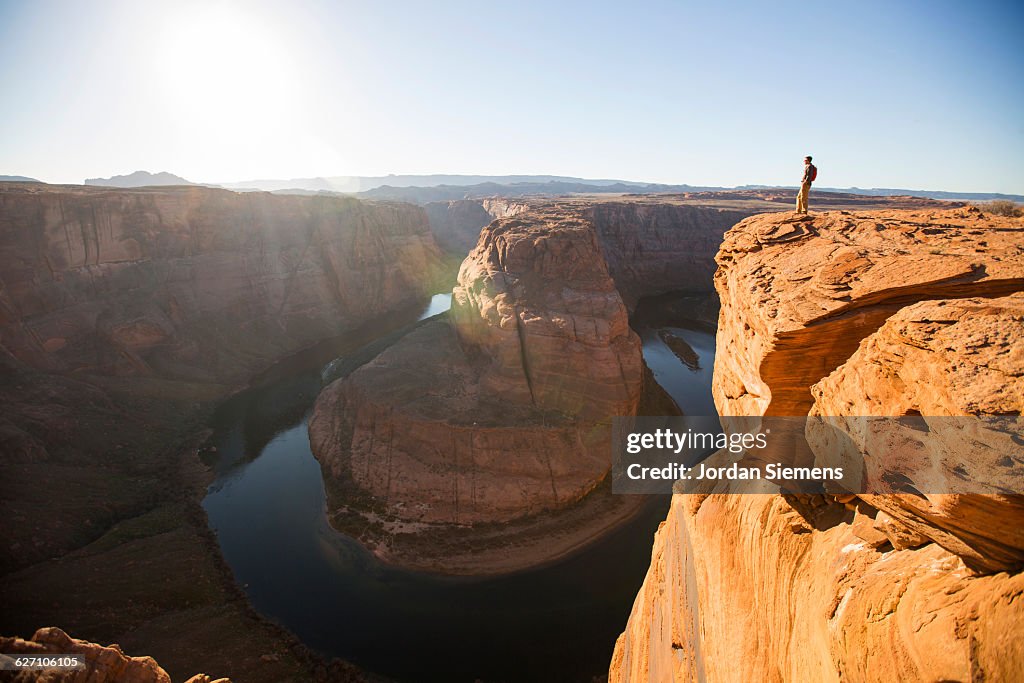 A man hiking on the edge of a senic overlook.
