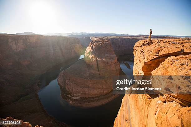 a man hiking on the edge of a senic overlook. - grand canyon - fotografias e filmes do acervo