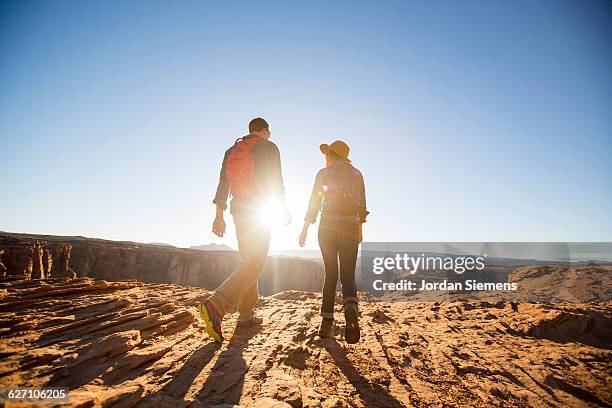 a couple hiking on the edge of a senic overlook. - backpage fotografías e imágenes de stock