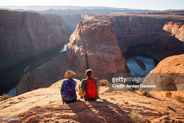 a couple hiking on the edge of a senic overlook. - parque nacional fotografías e imágenes de stock