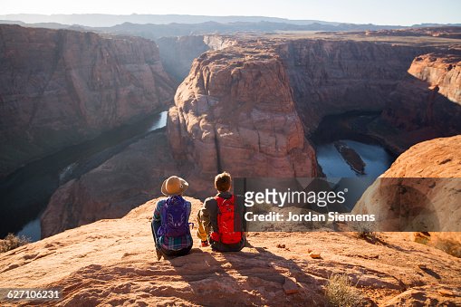 A couple hiking on the edge of a senic overlook.