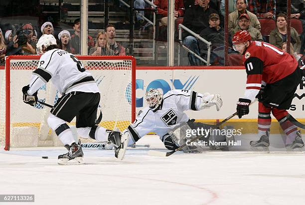 Drew Doughty of the Los Angeles Kings skates for a loose puck in front of Martin Hanzal of the Arizona Coyotes after a save by goalie Jeff Zatkoff of...