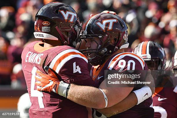 Quarterback Jerod Evans of the Virginia Tech Hokies celebrates his touchdown run against the Virginia Cavaliers with tight end Colt Pettit in the...