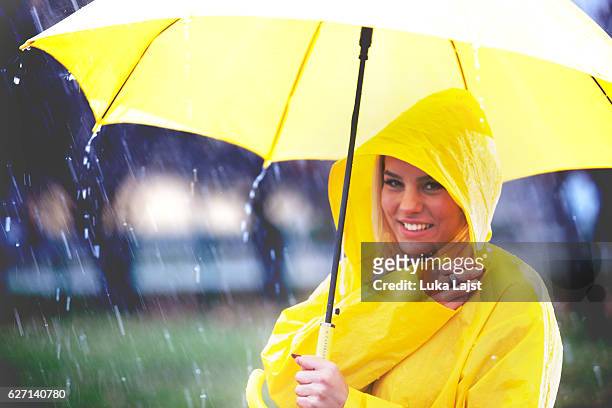 süßes mädchen bereit für den regen! - frau mit gelben regenmantel stock-fotos und bilder