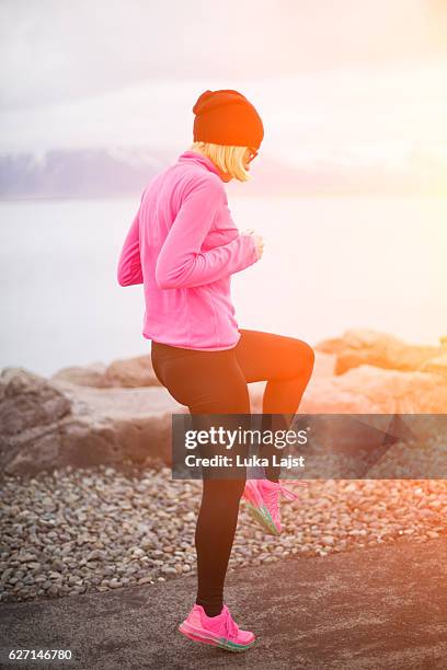 junge athlet frau läuft im island. - blurred running sunset stock-fotos und bilder