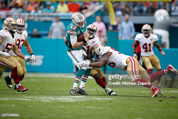 Ahmad Brooks and Gerald Hodges of the San Francisco 49ers sack Ryan Tannehill of the Miami Dolphins during the game at Hard Rock Stadium on November...