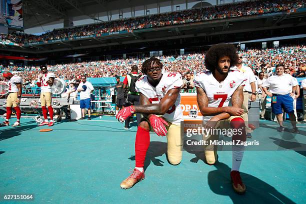 Eli Harold and Colin Kaepernick of the San Francisco 49ers kneel on the sideline, during the anthem, prior to the game against the Miami Dolphins at...