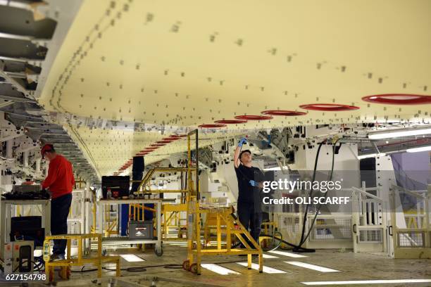 Airbus employees construct a wing for an Airbus A350 aircraft at Airbus' wing production plant near Broughton in north-east Wales on December 1,...